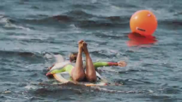 Meisje rijdt surfen board terwijl het opleggen van haar maag en rijen met haar handen — Stockvideo