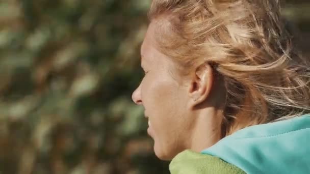 Detailní záběr portrét dívky squints oči na letní větrný den — Stock video