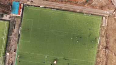 Sporcular yaz gününde yeşil çim sahada futbol oynarken hava Üstten Görünüm