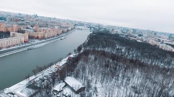 Vista aerea grande città coperta di neve, parco sul fiume, traffico di corsa su strada — Video Stock