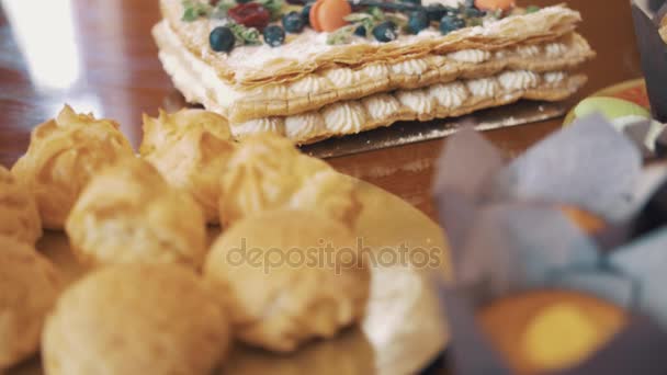 Produits de confiserie sur assiettes colorées décorées sur table de cuisine — Video