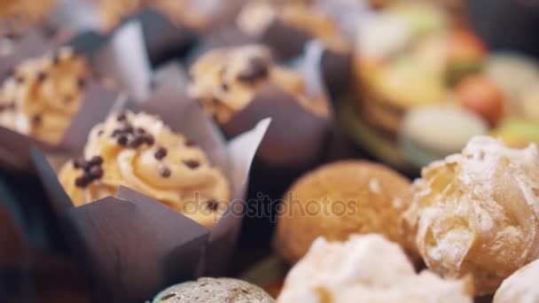 Suiker druppels op buttercreme wervelingen op mini gebak in bakkerij — Stockvideo