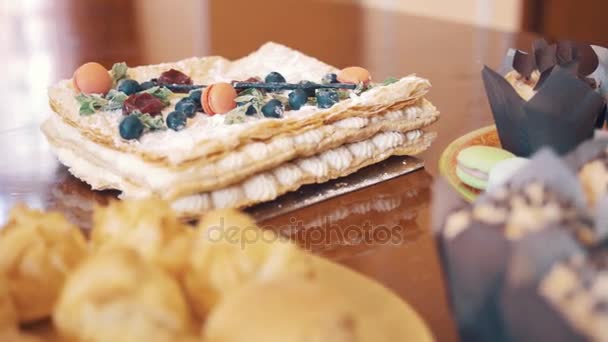 Pasticceria dolci cibi coloratamente decorati sulla scrivania prima del tea party — Video Stock