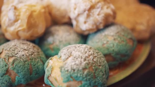 Sabrosos alimentos dulces coloridamente decorados en el escritorio antes de la fiesta del té — Vídeo de stock