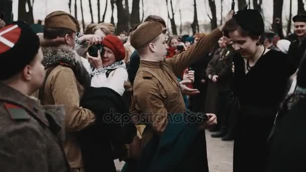 SAINT PETERSBURG, RUSSIA - Mei 9, 2017: Tentara Soviet membantu wanita berpakaian retro melepas mantel di acara sejarah — Stok Video