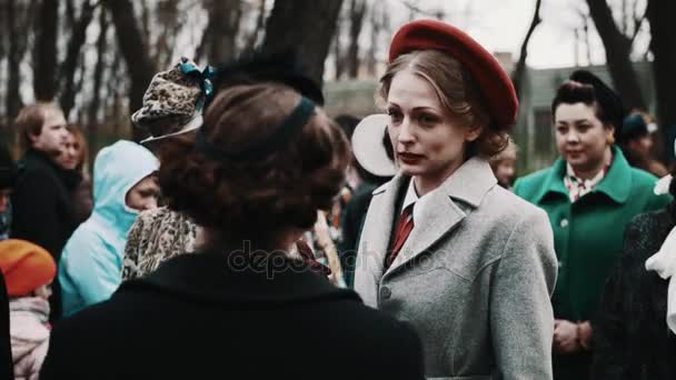 Petrohrad, Rusko - 9 května 2017: Štíhlá žena v retro kostýmu s červený baret mluví ve skupině — Stock video