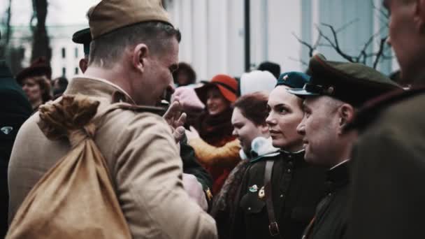 男性と女性のグループが話して、公園で笑顔のソビエト兵士に扮したサンクトペテルブルク, ロシア連邦 - 2017 年 5 月 9 日。 — ストック動画