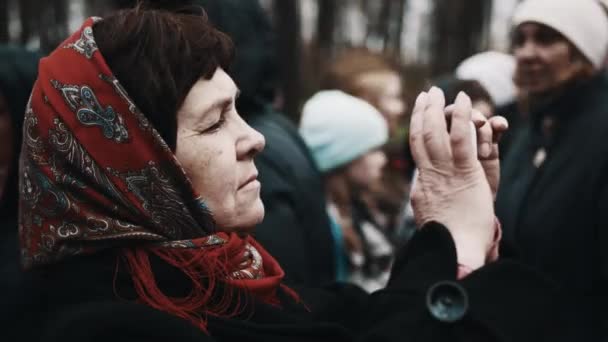 SAINT PETERSBURG, RUSSIA - 9 MAGGIO 2017: Vecchia donna con motivo floreale rosso velo sulla testa che scatta foto nel parco — Video Stock