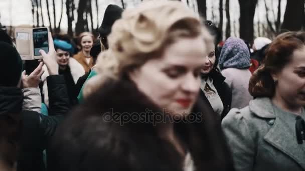 Sankt Petersburg, Ryssland - 9 maj 2017: Kvinnor i retro kostymer gå igenom korridoren av personer folkmassan på park — Stockvideo