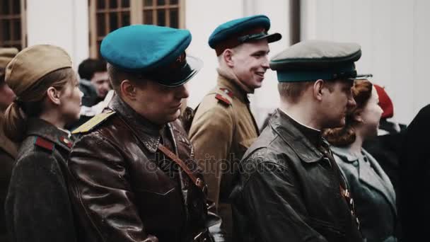 Sankt Petersburg, Rosja - 9 maja 2017: Kobieta i Grupa mężczyzn w starych żołnierzy radzieckich mundurach zaczyna chodzić w linii — Wideo stockowe