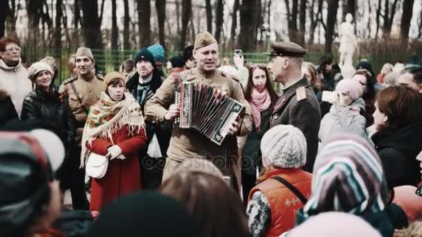 SAINT PETERSBURG, RUSSIE - 9 MAI 2017 : Homme en vieil uniforme de soldat soviétique jouant de l'accordéon et chantant avec la foule — Video