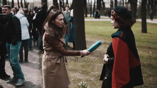 女性記者は、公園でのビンテージの服に女性からインタビューをサンクトペテルブルク, ロシア連邦 - 2017 年 5 月 9 日。 — ストック動画