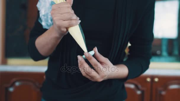 Confeiteiro mãos femininas espreme creme de enchimento fazendo macaron — Vídeo de Stock