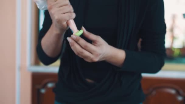 Confitero manos femeninas exprime relleno de crema de mantequilla de fresa haciendo macaron — Vídeos de Stock