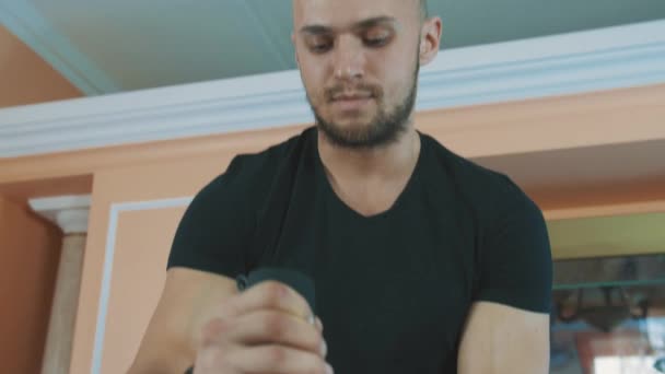 Kaslı adam whiped Creme cam kasede çırpma teli mutfak masasında kullanarak yapma — Stok video