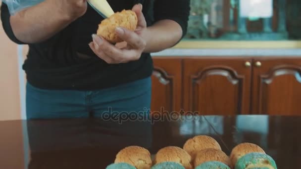 Konditorn kvinnliga händer kramar crème ut hylsan in profiterole — Stockvideo