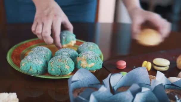 Жіночі руки кондитерських виробів розміщують на тарілці на столі — стокове відео