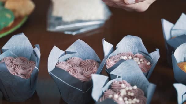 Pâtisserie cuisinier mains masculines décore muffin avec boules de bouffées de riz — Video