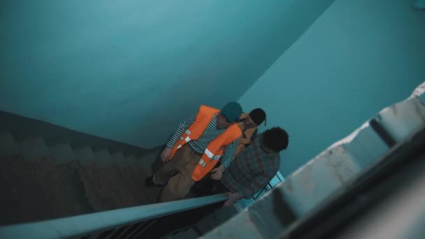 Drie midden leeftijd grappige mannen vuile werknemers lopen op stairscase, glimlachen — Stockvideo