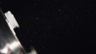 Karanlık odada spot ışık huzmesi toz lekeleri