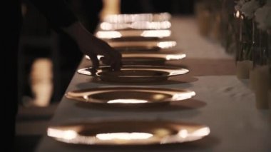 Yarı karanlık odada banket masada çatal yemek tabakları yakınındaki garson el koyar