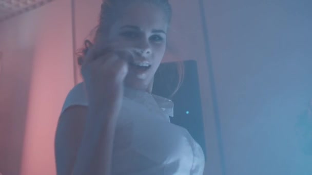 Filles attrayantes dansant à la fête dans la pièce fumée avec des lumières colorées — Video