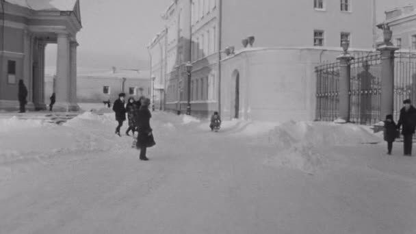 Saint Petersburg, Federacja Rosyjska, 1981: Starego rocznika film osób w zimie człowiek pchanie dziecka na sanie w mieście pokryte śniegiem — Wideo stockowe