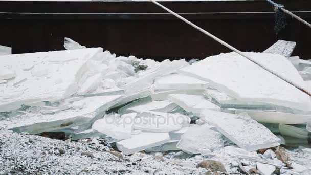 Mucchio di ghiaccio frantumato sotto il molo di metallo arrugginito sulla riva del lago ghiacciato — Video Stock