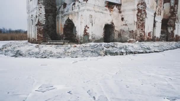 Покинута будівля собору посеред замерзлого озера, вкритого снігом — стокове відео