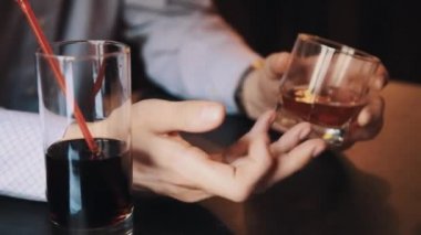 Elinde bir bardak viski tablo üzerine café'de tutan ekose gömlekli adam