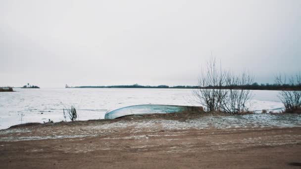 Landstraße, die zu einer Brücke mitten in einem zugefrorenen, schneebedeckten See führt — Stockvideo
