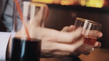 Elinde bir bardak viski üzerine tablo lokantada tutan ekose gömlekli adam
