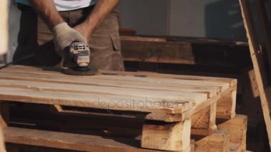 Woodworker adam ahşap plakalar yapısını düzeltmek için açılı taşlama makinesi kullanın