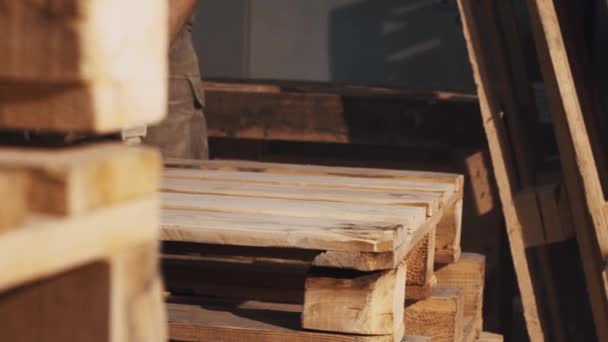 El hombre carpintero utiliza la máquina amoladora angular para suavizar la estructura de tablas de madera — Vídeo de stock