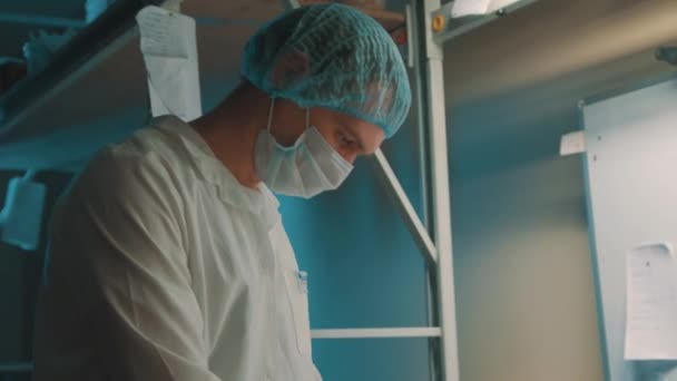 Worker man in sterile clothes put piece of kinetic sand on weights — Stock Video