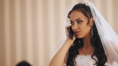 Genç gelin gelinlik ve cep telefonuyla konuşurken vail kadında