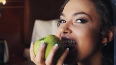 Genç gelin düğün elbise ve ısırıkları gülümseme ile yeşil elma vail