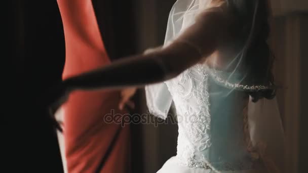 Jonge bruid meisje in bruiloft jurk gooit open gordijnen in halve donkere kamer — Stockvideo