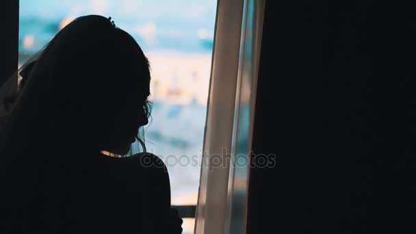 Σιλουέτα της νύφης κορίτσι που περιμένει τον αρραβωνιαστικό μπροστά από το παράθυρο — Αρχείο Βίντεο