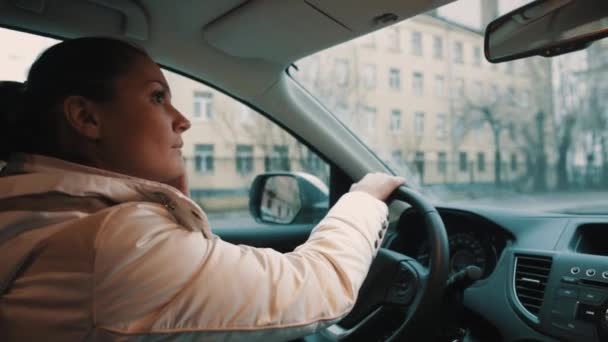 Mladá žena volá na mobilním telefonu během jízdy auto koryto město ulice — Stock video