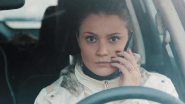 Genç esmer kadın arabada oturmuş, kar yağışı telefon mobil söz
