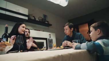 Aile ve arkadaş akşam yemeği masasında var içecekler ve clings gözlük, kutlama