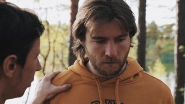 Uzun saçlı kızgın adam ormanda arkadaşıyla tartışıyor