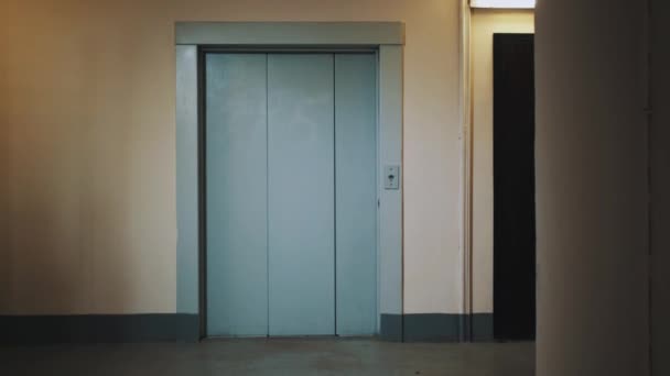 Guy lopen uit lift met koffer in slaapzaal huis corridor — Stockvideo