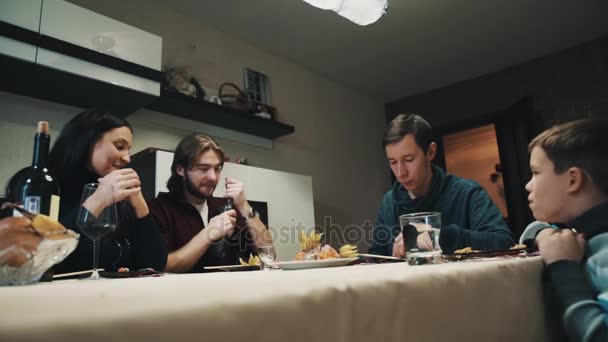 Familj och vän på middagsbordet dricker vodka och äter sushi, firande — Stockvideo