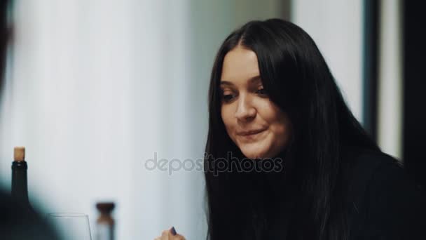 Joven morena juguetona mujer sonriendo y hablando en la mesa de la cena — Vídeos de Stock