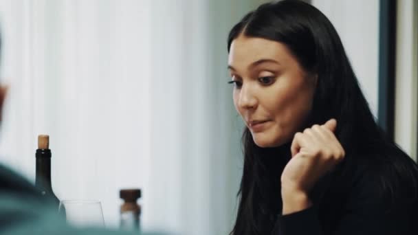 Glad ung kvinna aktivt pratar på middagsbordet medan vissa firande — Stockvideo