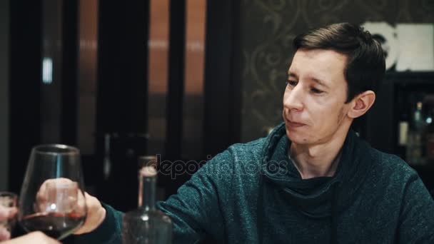 Subtilní mladík pije vodka shot s přáteli na jídelní stůl — Stock video