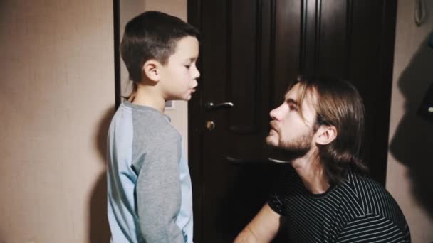 Niño habla con el padre de pelo largo en el pasillo del apartamento — Vídeo de stock