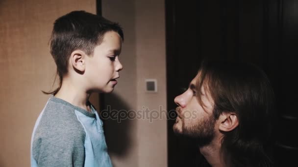 Pequeno filho fala com pai de cabelos compridos no corredor do apartamento — Vídeo de Stock